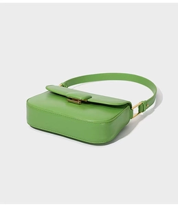 Detail of green leather shoulder bag with sleek gold buckle and adjustable strap