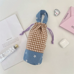 Detail of plaid and star patchwork drawstring bottle bag with purple woven handle