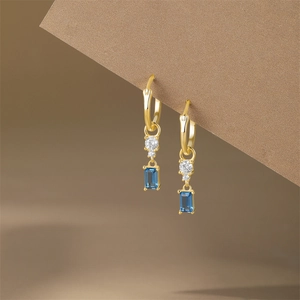 Detailed shot of S925 silver gold earrings with blue rectangular gemstone and white zircon