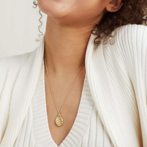 Minimalist 18K gold-plated oval locket necklace with wavy textured pendant on a model