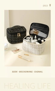 Detailed view of tweed makeup bag set with leather handle and layered storage compartments