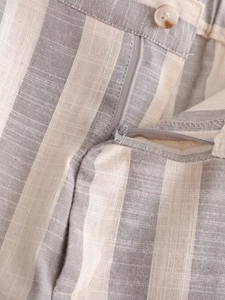 Détail du tissu rayé gris aspect lin avec fermeture éclair et bouton fonctionnels
