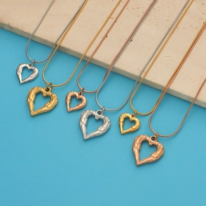 Detail of heart angel wing pendants in silver, gold, and rose gold stainless steel