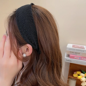 Detailed macro view of a black woven headband featuring a stereoscopic wave texture pattern