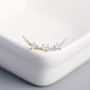 Macro view of curved S925 silver twig earrings with marquise-cut cubic zirconia