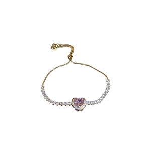 Adjustable golden bracelet featuring a pink heart stone and white cubic zirconia accents