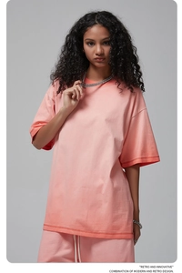 Detail of drop shoulder crewneck t-shirt in washed orange pink cotton knit fabric