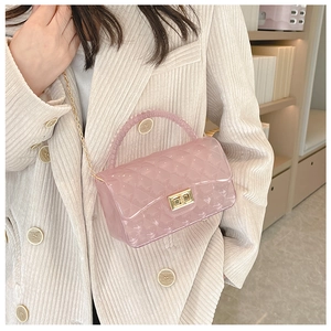 Fashionable pink jelly crossbody bag with diamond lattice pattern on a beige blazer model