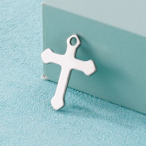 Polished silver stainless steel cross pendant necklace charm on a light blue background