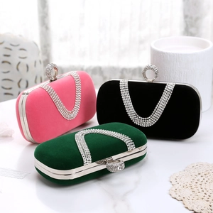 Detailed view of luxury velvet evening clutches in pink, black, and green with crystal rim