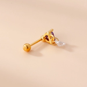 Golden cartilage stud earring with heart purple zircon and clear pendant on skin background