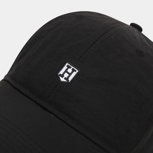 Gros plan de la broderie en écu sur une casquette de baseball en nylon noir