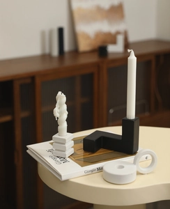 Artistic detail of minimalist ceramic candle holders on a book with matte texture