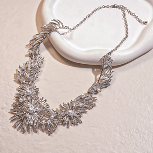 Chic silver coral-shaped necklace with pearls on an elegant ivory display tray