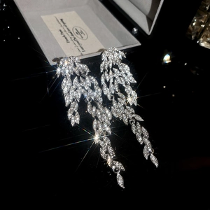 Close-up of sparkling rhinestone feather tassel earrings on a luxury jewelry box
