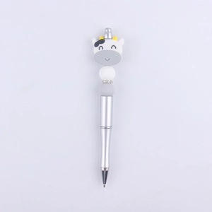 Detail of cute cartoon cow silicone bead design on a silver metallic ballpoint pen