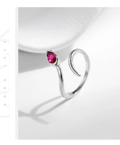 Macro shot of S925 sterling silver stamp and red pear-shaped zircon on snake ring
