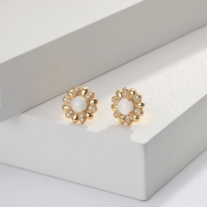 Nahaufnahme der Blumenohrringe mit Opal-Zentrum und Zirkonia-Blütenblättern in Gold