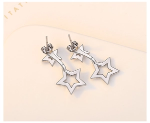 Macro view of double hollow star earrings in silver finish with secure needle backing