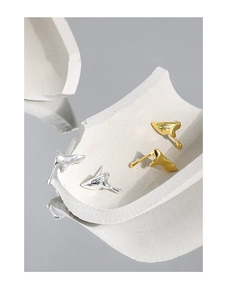Macro detail of irregular lava-style earrings in silver and gold with mirror finish
