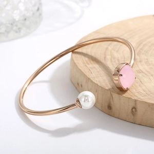Dettaglio del bracciale a C in oro rosa con una perla bianca e una pietra rosa