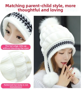 Dettaglio del cappello in maglia bianca con tre pompon e fodera in pile calda