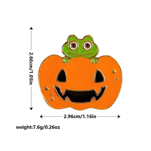 Détail de l'épinglette grenouille citrouille avec dimensions 2,66cm par 2,96cm