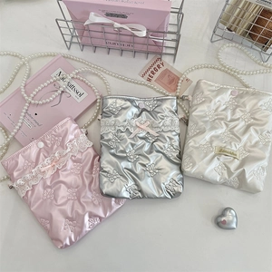 Dettaglio di mini borse in PU trapuntato con fiocchi e tracolle in perle in tre colori