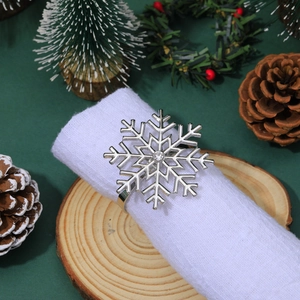 Silver rhinestone snowflake napkin ring on white fabric with festive Christmas decor