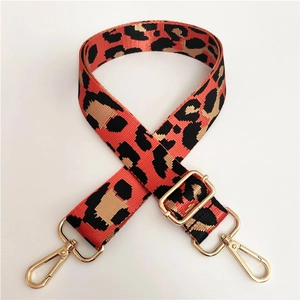 Close-up of leopard print bag strap with golden metal hooks and adjustable buckle