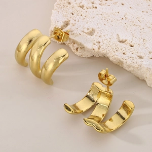 Polished gold-plated stainless steel triple C-shape hoop earrings on white stone