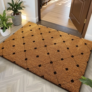 Macro detail of natural coconut fiber doormat with black diamond pattern on wood floor