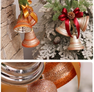 Macro detail of Christmas bells with gold glitter finish, pine cones and festive ribbons