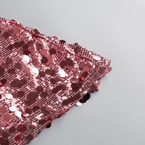 Close-up of shimmering rose pink metallic sequins on luxury party dress fabric