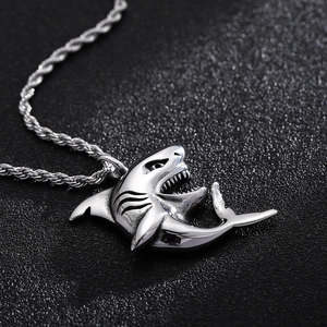 Close-up of a silver shark pendant with twisted rope chain in a hip-hop style