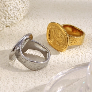 Close-up of gold and silver chunky rings with hammered texture and abstract eye design