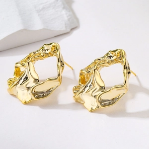 Close-up of gold-plated earrings with unique irregular molten metal texture details