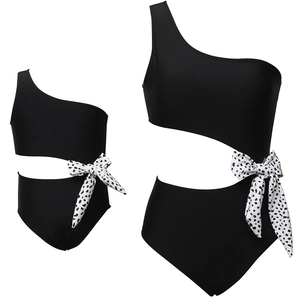 One-shoulder black one-piece swimsuit with cutout and polka dot bow for mother and child
