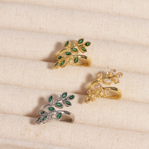 Détail de bagues feuilles avec émeraude marquise et pierres roses en or et argent