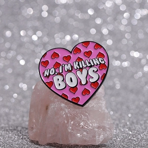 Détail du pin's coeur rose émaillé avec slogan sur un support en cristal minéral
