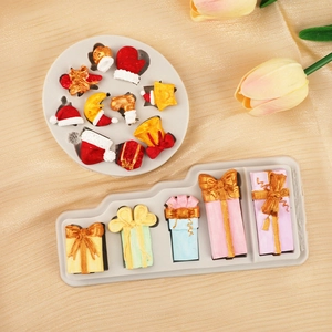 Christmas silicone molds featuring Santa hats, bells, and gift boxes for fondant cake decor