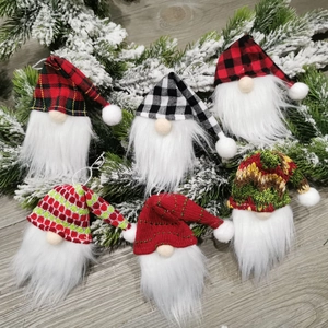 Detailed view of six Christmas gnome ornaments with plaid hats on rustic wood background