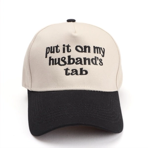 Detail of embroidered 'put it on my husband's tab' text on two-tone baseball cap