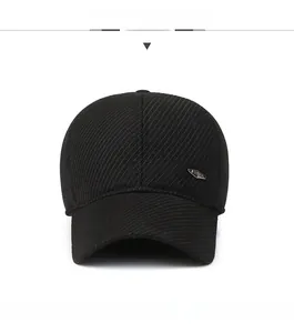 Detail of black winter baseball cap showing thick twill fabric and silver metal badge