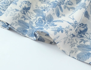 Close-up of blue floral and swallow print on lightweight chiffon dress fabric
