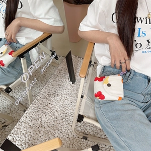 Mini floral canvas storage bag attached to jeans belt loop with a purple hook