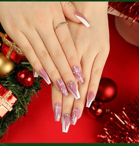 Detailed view of coffin press-on nails with white snowflakes and rhinestones for Christmas