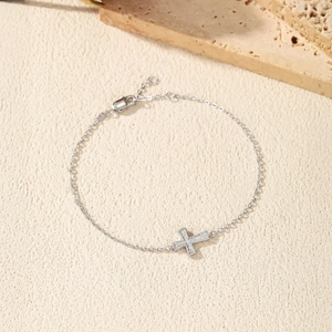 S925 sterling silver cross bracelet with Moissanite pavé stones on a textured surface