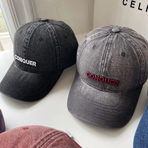 Close-up of vintage washed denim baseball caps with CONQUER 3D embroidery detail
