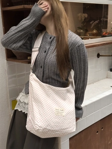 Close-up of adjustable strap and pink polka dot print on large canvas tote bag